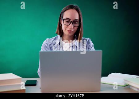 Bored Girl In Classroom Using Computer Technology. Laptop In Education Stock Photo