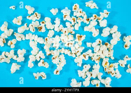 Top view of scattered popcorn on a blue background, cinema food concept Stock Photo