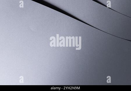 Elegant designer paper background with a smooth, glossy metallic gradient in rich gray tones. This closeup showcases fine texture and geometric lines, Stock Photo