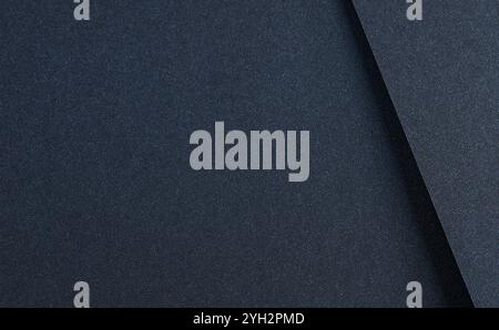 Luxurious designer paper background in deep navy blue with a smooth, shadowed texture. This dark, minimalist surface features elegant folds and geomet Stock Photo