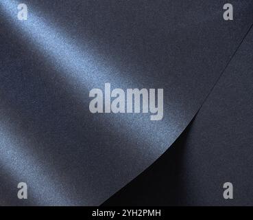 Luxurious designer paper background in deep navy blue with a glossy, satin finish and rich gradient. This sophisticated, abstract surface features wav Stock Photo