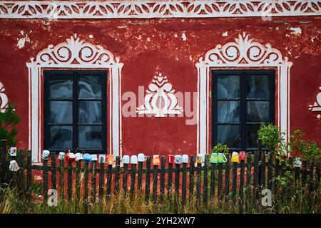 Wall art on the front of a house with a collection of mugs on the wooden picket fence. Stock Photo