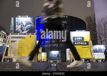 A person crosses the former strip of the Wall in front of the exhibition in front of the asisi Panorama Berlin Die Mauer / The Wall on the 35th annive Stock Photo