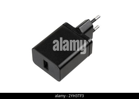 A black USB wall charger with a European plug, isolated on a white background, suitable for charging various electronic devices. Stock Photo