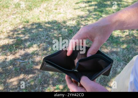 Man holding empty black leader partmone in the hands. The wallet without for commerce concept. Stock Photo