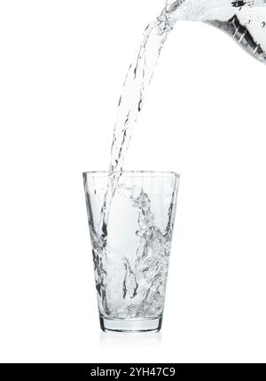 Pouring soda water from jug into glass on white background Stock Photo