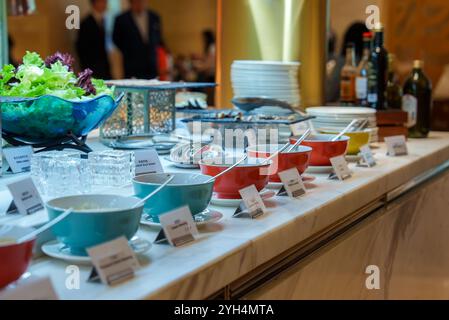 Buffet Setup with Colorful Bowls and Fresh Lettuce on Marble Countertop Stock Photo