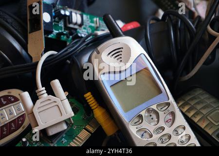 Outdated telecommunication technologies. Electronic waste for recycling. e-waste pile of old phones and circuits. Stock Photo