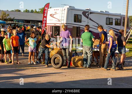 Children wait in line to participate in a tire rolling contest at the Allen County Fair's Fun Zone in Fort Wayne, Indiana, USA. Stock Photo