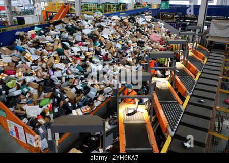 ZAOZHUANG, CHINA - NOVEMBER 10, 2024 - Staff sort express deliveries at the network operation center of the delivery division of China Post Group Co L Stock Photo