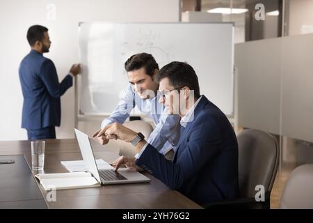 Two diverse business coworker men watching Internet project presentation Stock Photo