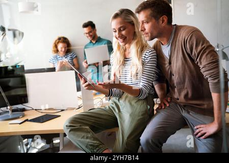 Two young businesspeople using a digital tablet while standing in a boardroom. Stock Photo