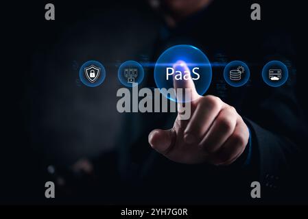 businessman interacts with PaaS technology icons, focusing on secure cloud computing solutions. Suitable for IT and business technology promotions. Stock Photo