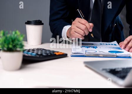 Professional analyzing financial charts and reports with a pen. Ideal for business analysis, financial planning, investment strategies, or corporate c Stock Photo