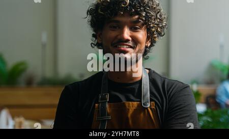 Happy successful Latino American ethnic man male smiling joyful worker in apron guy waiter cleaner barista cheerful small business owner looking Stock Photo