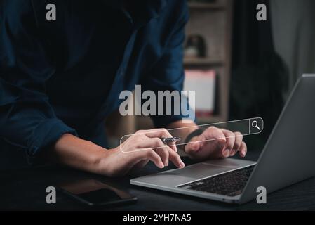 Hands typing on a laptop with a search bar interface, symbolizing online search. Suitable for internet research, search engine optimization SEO, and d Stock Photo