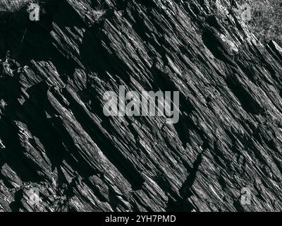 Beautiful dark grey surface stone texture background, black and white style. The strong cliff rock, cracked pattern. The jagged surface of the large r Stock Photo