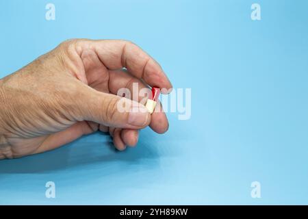 Pills in a black bowl on a blue background. Medical concept Stock Photo