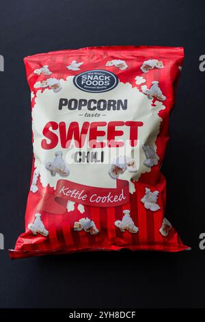Soft package of kettle cooked popcorn with sweet chili taste. Isolated on black background. Copenhagen, Denmark - November 10, 2024. Stock Photo