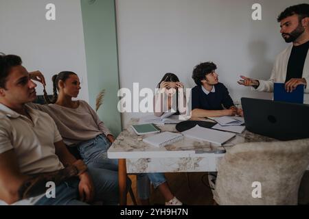 High school students collaborating with professor at home after school Stock Photo