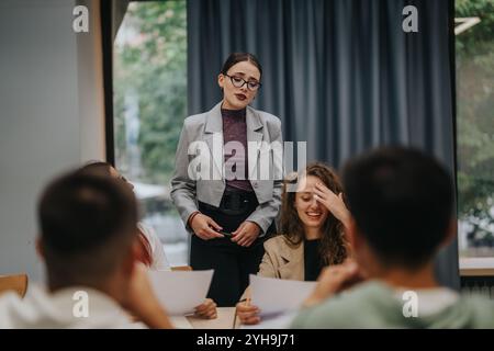 Teacher engaging with students in a modern classroom setting Stock Photo
