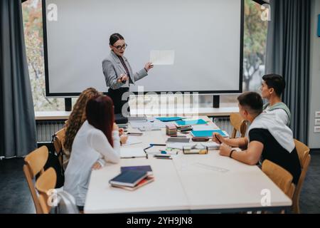 Teacher giving presentation to attentive students in modern classroom Stock Photo