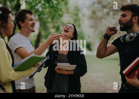Multicultural students collaborating on assignments in the park after class Stock Photo