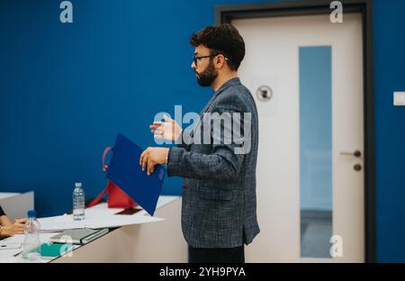 Professor assisting students during class with assignments Stock Photo