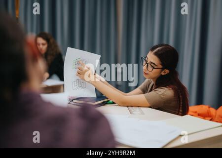 Engaged students in a classroom setting sharing ideas and discussing project designs while focusing on educational progress and collaboration during a Stock Photo