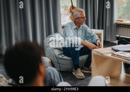 Professor engaging with students in a relaxed classroom setting Stock Photo