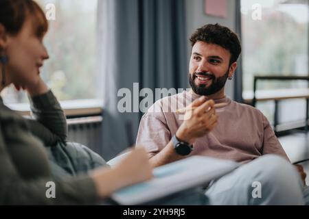 Young male professor engaging with students in a relaxed setting Stock Photo