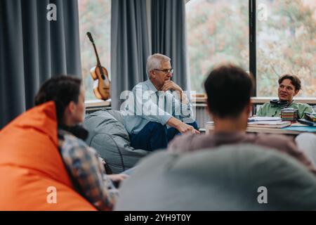 Professor engaging with students in a relaxed classroom setting Stock Photo