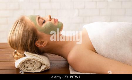 Millennial woman in spa salon with mask on face Stock Photo