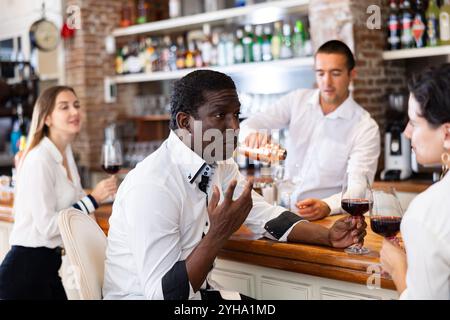 Adult couple communicates with each other while sitting at the bar in restaurant Stock Photo