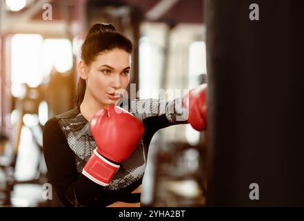 Sports concept. Young woman boxer working out in gym Stock Photo