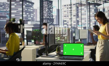 Focus on chroma key laptop in workspace used by computer scientists doing software debugging. Close up of isolated screen notebook used by workers in office fixing coding issues, camera B Stock Photo