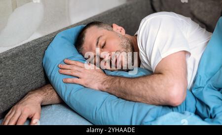 Mature Man Sleeping Hugging Pillow Lying In Bed At Home Stock Photo