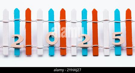 Número 2025 de madera apoyado en una valla pintada de colores Stock Photo