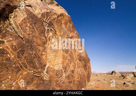 Moonlight lights up the 'Crazy Woman' petroglyph carved thousands of years ago on a boulder near Dubois, Wyoming. Stock Photo