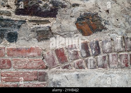 Detail of an arch above a cemented window on the exterior wall of an old brick building Stock Photo