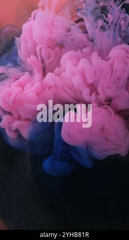 Color blending. Sparkling cosmetic. Art design. Blue pink texture in blending flow together on blurred modern gleaming orange abstract background. Stock Photo