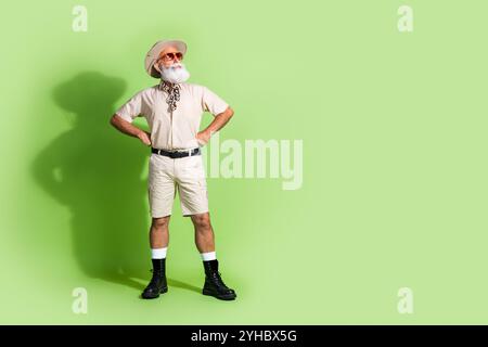 Adventurous senior man explores the vibrant wilderness in a stylish safari outfit, showcasing his passion for nature and travel Stock Photo