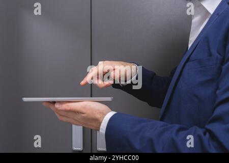 Close-up of businessman using digital tablet while standing in locker room Stock Photo
