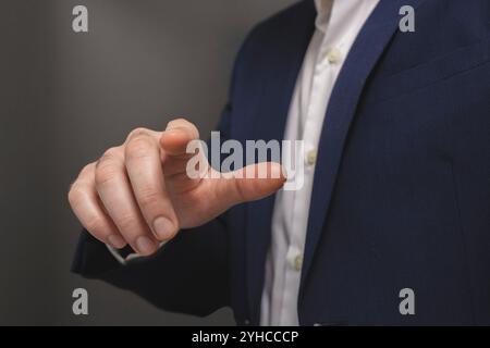 Businessman pressing virtual button on grey background, closeup. Finger pressing button Stock Photo