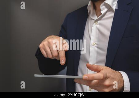 Businessman using digital tablet. Closeup of male hands touching screen of tablet Stock Photo