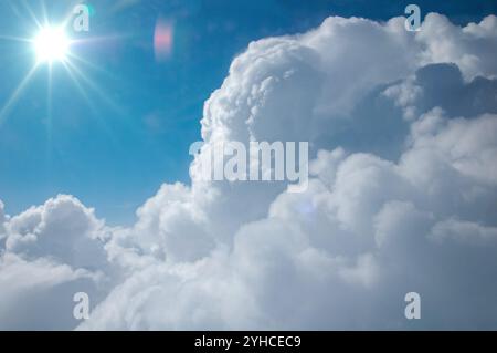 White clouds on blue sky background in the morning and Sun. Clouds and blue sky as seen through an airplane window Stock Photo