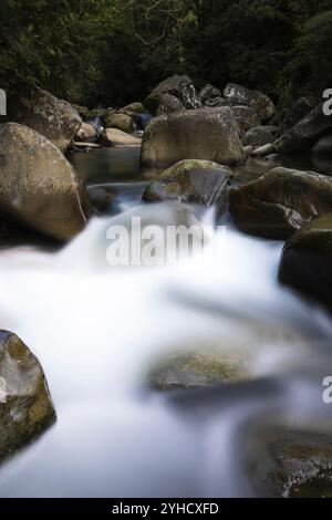 Slow shutter image of water flowing through the rocks creating a smooth silky effect in Taiwan Stock Photo