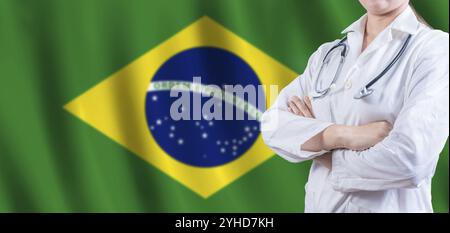 Doctor with crossed arms on Brazilian flag. Brazilian Health and Care concept. Female doctor on Brazil flag Stock Photo