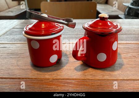 Milk and sugar jug, red with white dots, enamel crockery Stock Photo