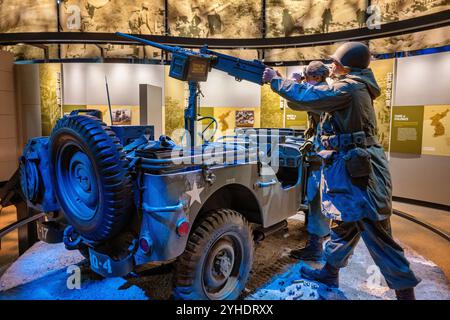 World War II Jeep Exhibit National Museum Of The United States Army Fort Belvoir Virginia | FORT BELVOIR, Virginia — Two mannequin soldiers work a .50-caliber machine gun mounted on a Willys Jeep in a snow-covered Korean War diorama at the National Museum of the United States Army, illustrating the "Years of Stalemate" phase of the conflict from 1951 to 1953. Spent shell casings and ammunition boxes lie scattered around the vehicle, reinforcing the battlefield setting. Stock Photo